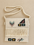 Handmade bag with geometric patterns and fringes on a beige background