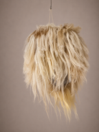 The back of a fuzzy mask with blonde hair, red nose, and black eyes on a plain background