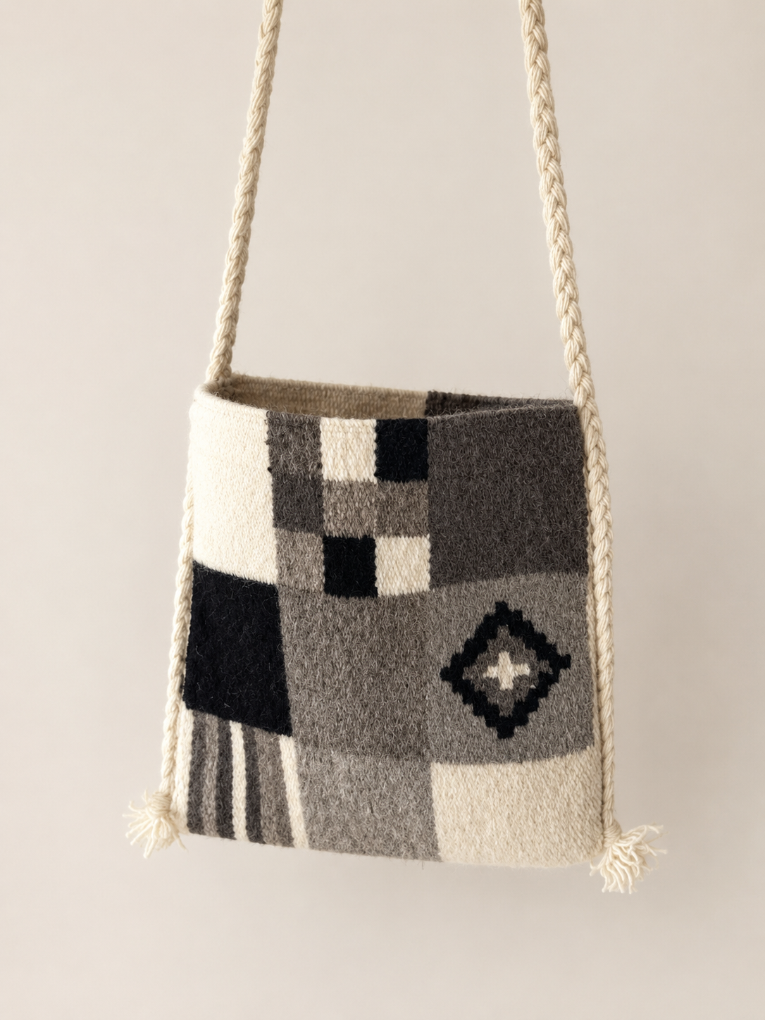 Checkerboard-patterned bag with geometric patterns on a beige background