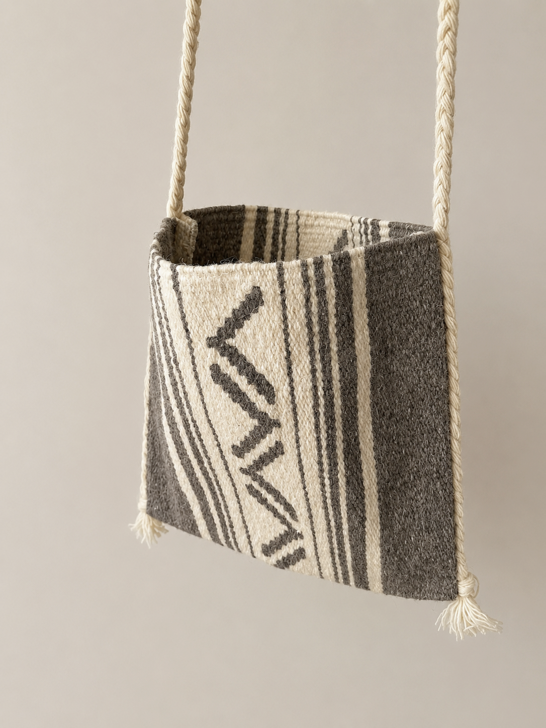 Textured bag with geometric pattern hanging against a neutral background