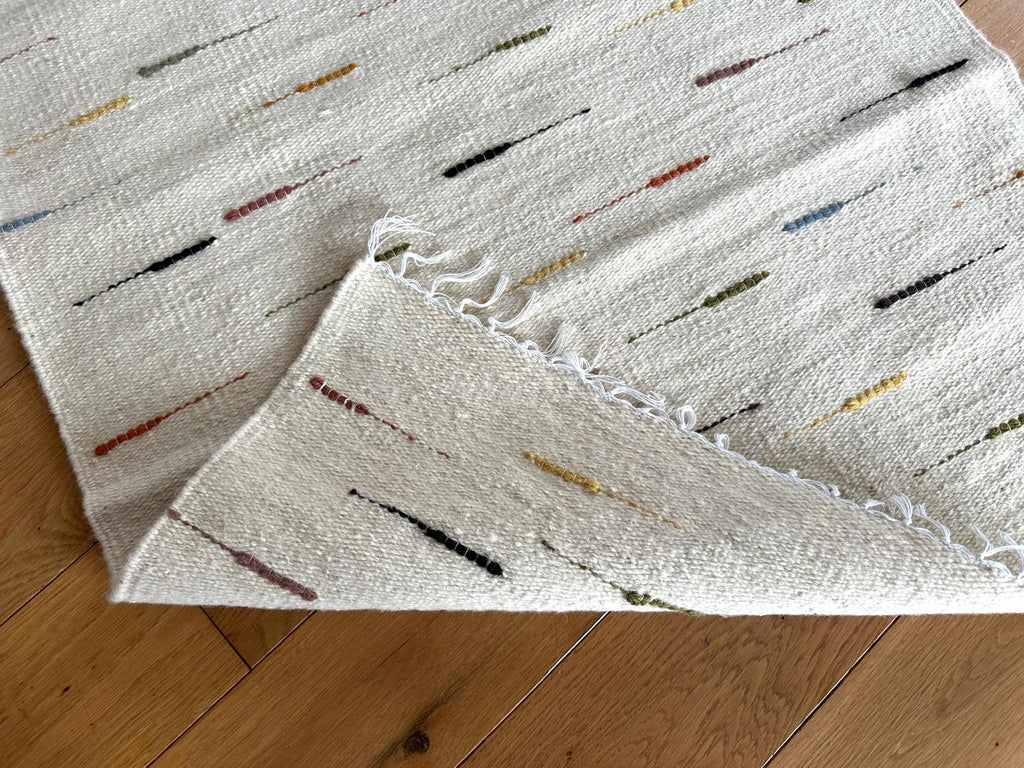 Textured rug with colorful accents on a wooden floor