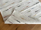 Textured rug with colorful accents on a wooden floor