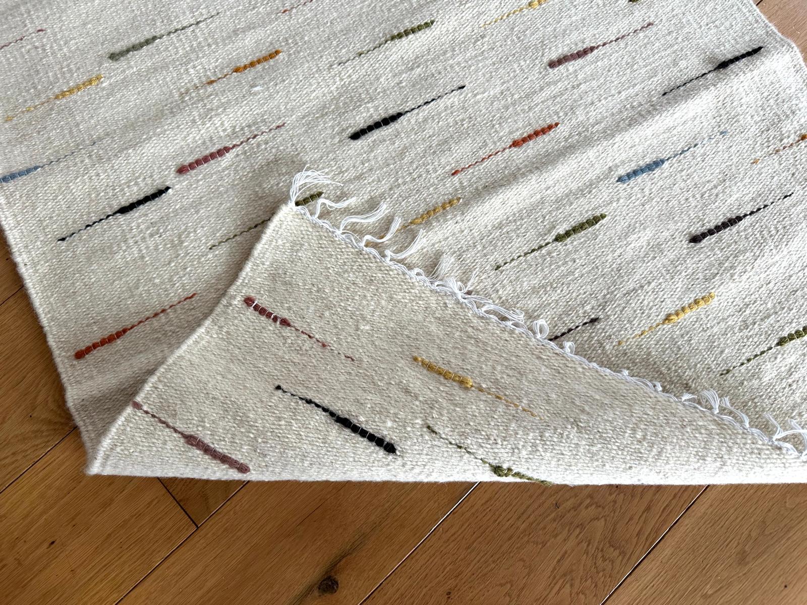 Textured rug with colorful accents on a wooden floor